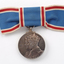 Close up of blue ribbon tied into bow with medal hanging down