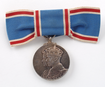 Close up of blue ribbon tied into bow with medal hanging down