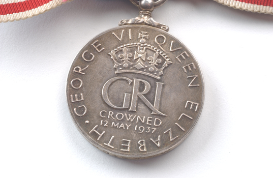 Inscription on back of medal hanging from ribbon
