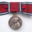 Red ribbon tied into bow with silver medal hanging down
