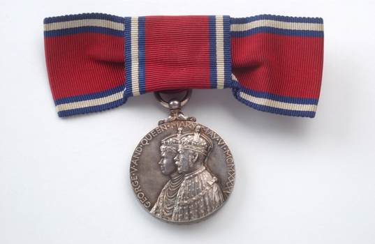 Red ribbon tied into bow with silver medal hanging down