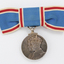 Blue ribbon tied into bow with silver medal hanging down