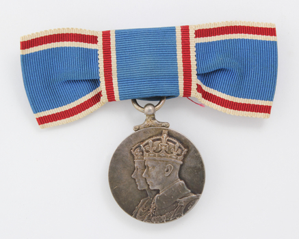 Blue ribbon tied into bow with silver medal hanging down