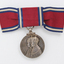 Red ribbon tied into bowtie with hanging silver medal