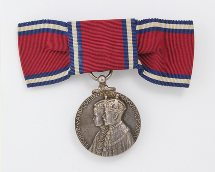 Red ribbon tied into bowtie with hanging silver medal