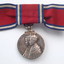 Red ribbon tied into bow with silver medal