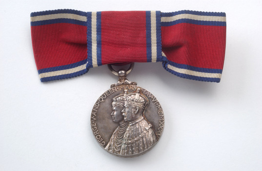 Red ribbon tied into bow with silver medal