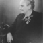 Seated older lady with two coronation medals pinned to her left breast