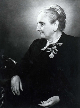 Seated older lady with two coronation medals pinned to her left breast