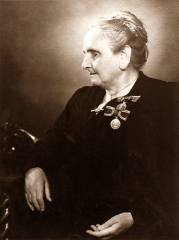 Seated older lady with two coronation medals pinned to her left breast