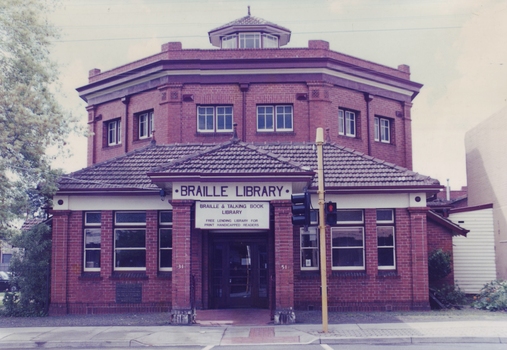 Red brick octagonal building with traffic light outside entrance