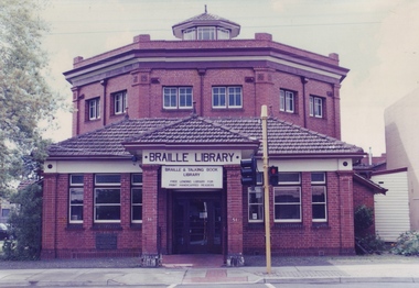 Red brick octagonal building with traffic light outside entrance