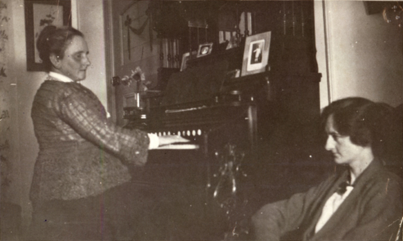 Woman playing organ whilst another woman listens