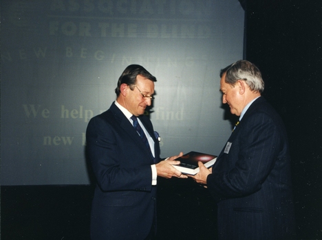 John Moule presenting book to a man