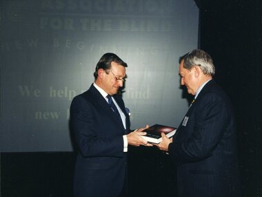 John Moule presenting book to a man