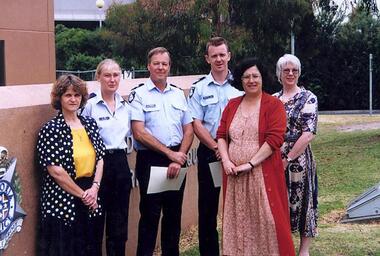Three VA staff and three Victoria police officers outside a station