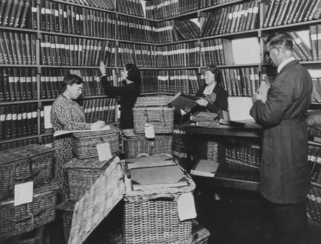 Four people working in Braille library, with wicket baskets ready to dispatch books