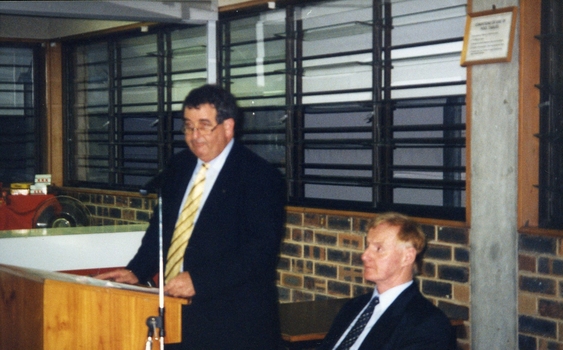 John Puttick at the podium with Professor Ron McCallum sitting next to him