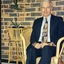Peter Lynam, First Chief Executive Officer of Vision QLD, sitting in a cane chair