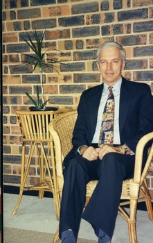 Peter Lynam, First Chief Executive Officer of Vision QLD, sitting in a cane chair