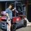 Unknown man stands next to a forklift