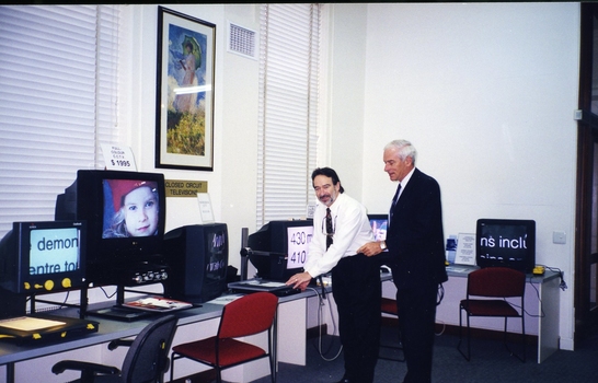 Peter Lynam with an unidentified man at the screen magnifier display 