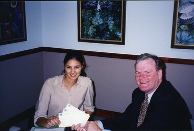 Geoff Melvin hands cheques to unidentified female