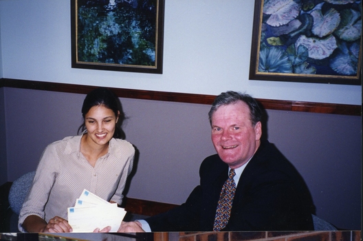 Geoff Melvin hands cheques to unidentified female