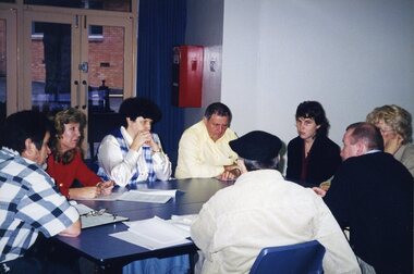 Eight people sit around a table, including Henry Chichowski, Tracey Millwood and Kevin O'Mahoney