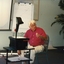 Man seated as he uses overhead projector