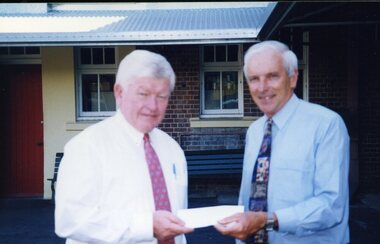 Tim Quinn handing cheque to Peter Lynam