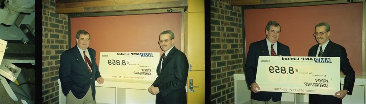 John Puttick receiving a cheque from an AMP representative