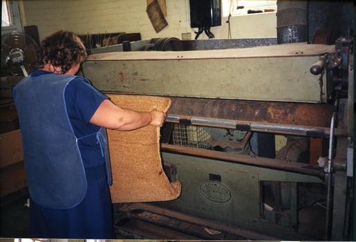 Unidentified female with a machine on the factory floor
