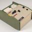 Green and cream box with black levers and removable plastic cartridge housing magnetic tape.