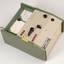 Green and cream box with black levers and removable plastic cartridge housing magnetic tape.