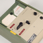 Green and cream box with black levers and removable plastic cartridge housing magnetic tape.