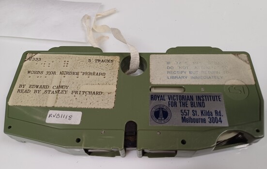 Green cartridge with labels and containing analog magnetic tape