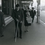 Man using white cane as he walks along busy city street