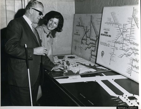 Man feels tactile map of Sydney with a woman beside him