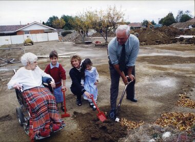 Mary Tiernan and her family look on as Rex Hollioake turns the sod