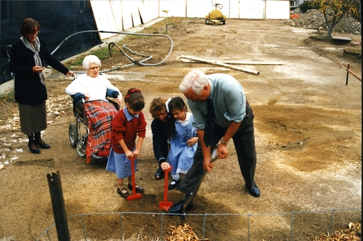 Mary Tiernan and her family look on as Rex Hollioake turns the sod