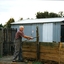 Older man in overalls removing a retaining wall