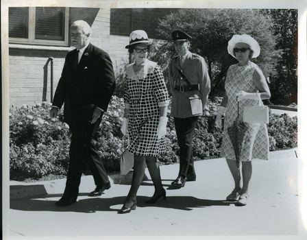 Sir and Lady Delacombe walk the grounds with Kitty Rose and another person