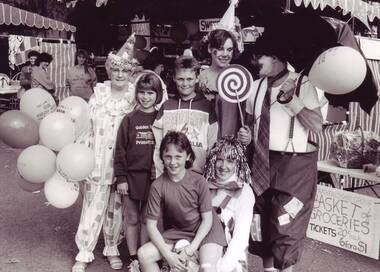 Four adults dressed as clowns with some children