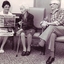 Lady reads Bendigo Advertiser to two elderly people seated in lounge at Mirridong