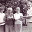 Man shakes hands with a woman as he hands her a piece of paper, with two others having already received theirs