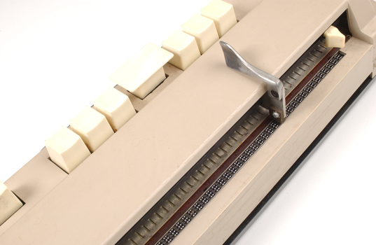 Beige rectangle box with cream buttons and braille display