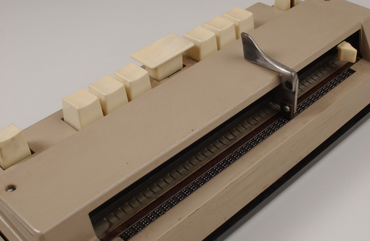 Beige rectangle box with cream buttons and silver return lever