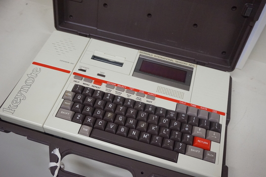 Cream keyboard with brown keys, 'Keynote' written on side, red line and cassette unit above keys