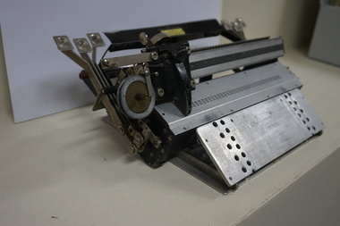 Metal rectangular plates joined with metal keys and connecting puncher that moves across the page